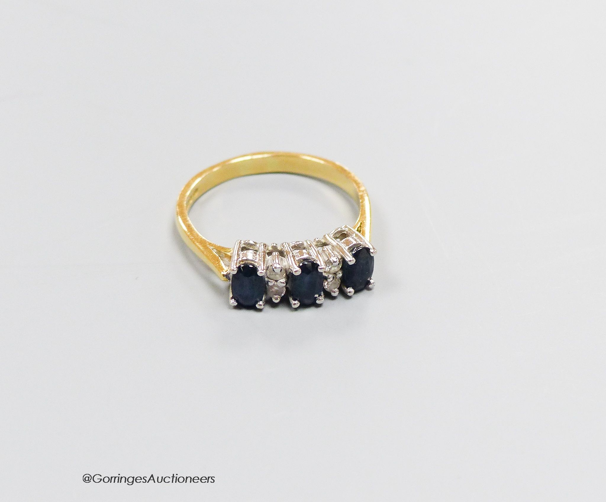 An 18ct gold sapphire and diamond dress ring, size N, gross 3.4g.